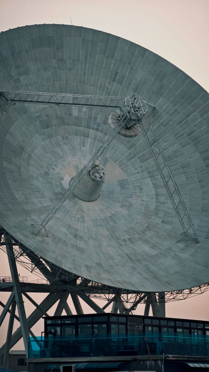 A close-up of a large satellite dish against a clear sky, showcasing technology and communication.